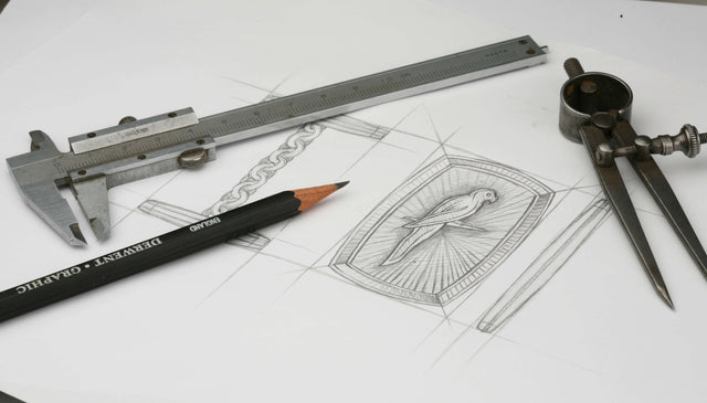 A hand drawing of a cufflink with a bird on it.